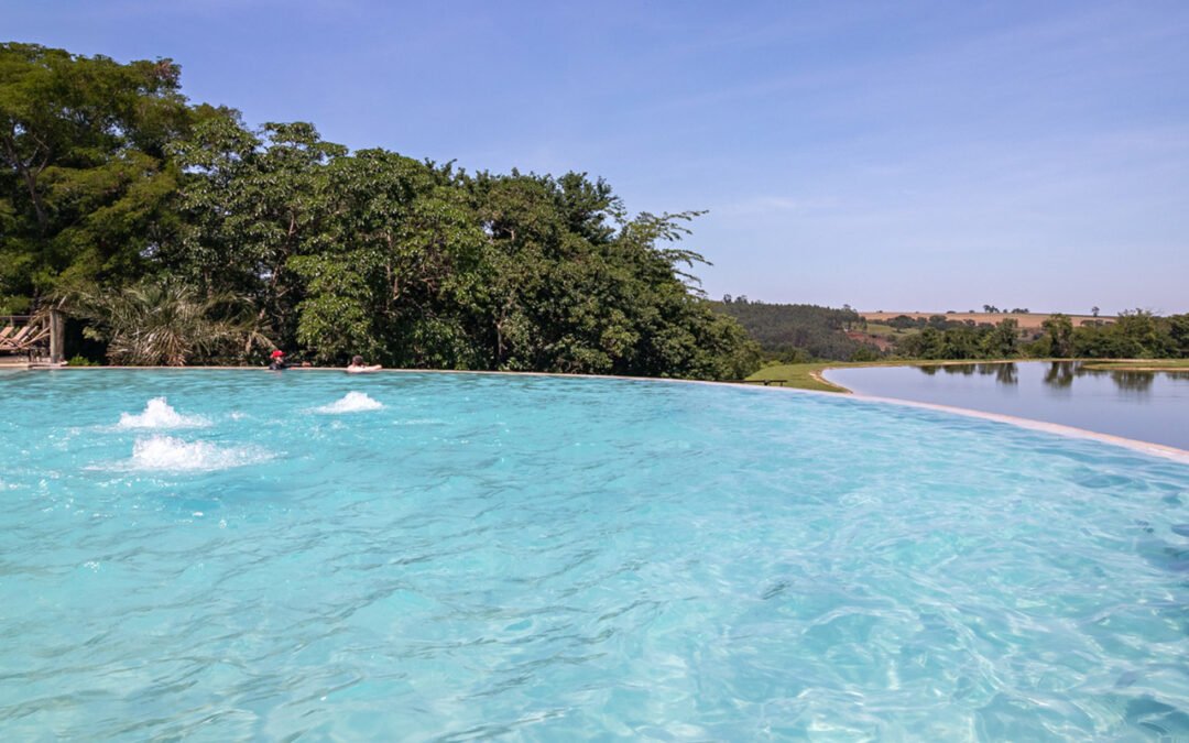Piscina de borda infinita com vista para o vale em um dia de sol